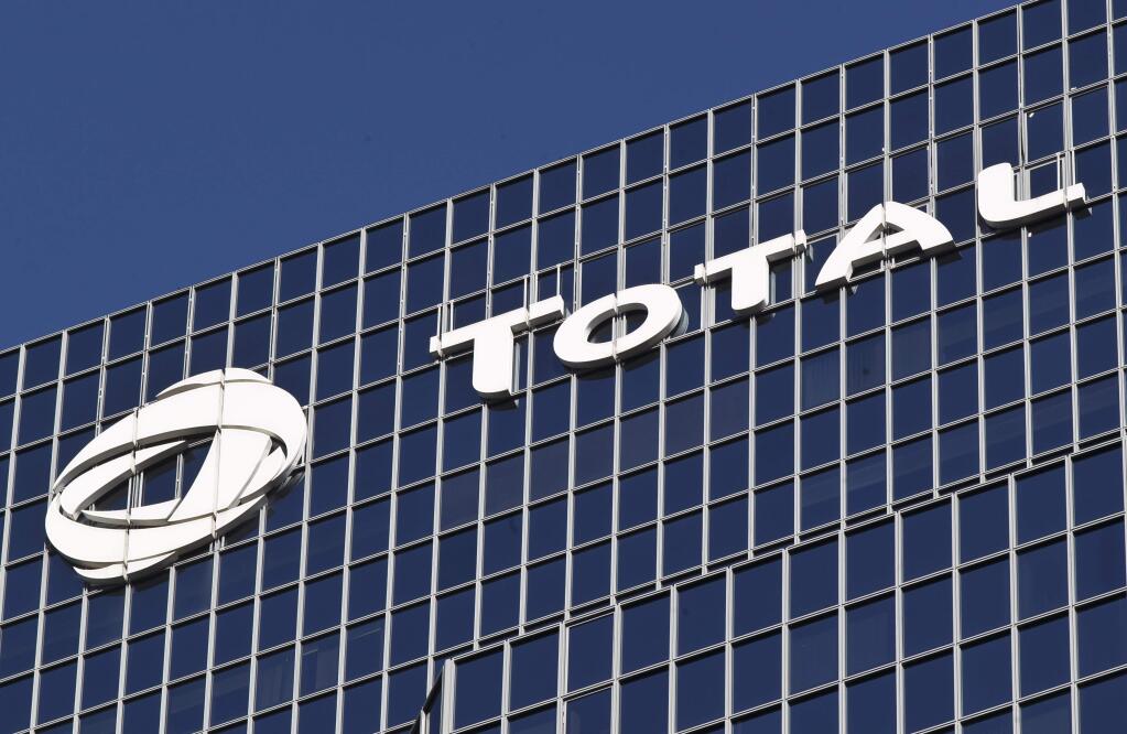 FILE - In this Jan.11, 2016 file photo, the logo of French oil giant Total SA is pictured at its headquarters in La Defense business district outside Paris. The billionaire French donors including Patrick Pouyanne, CEO of French energy company Total, publicly promised flashy donations to restore Notre Dame, but it's mainly American citizens that have footed the bills and paid salaries for the up to 150 workers employed by the cathedral since the April 15 fire. (AP Photo/Michel Euler, File)