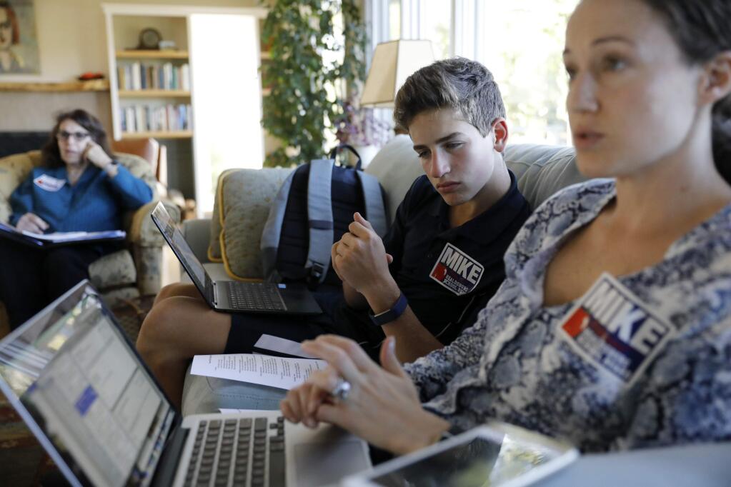 Eighth grader Jackson Boaz looks over the shoulder of volunteer Ariel Kelley as they attend a campaign meeting for Healdsburg School Board candidate Mike Potmesil on Monday, September 17, 2018 in Healdsburg, California . (BETH SCHLANKER/The Press Democrat)