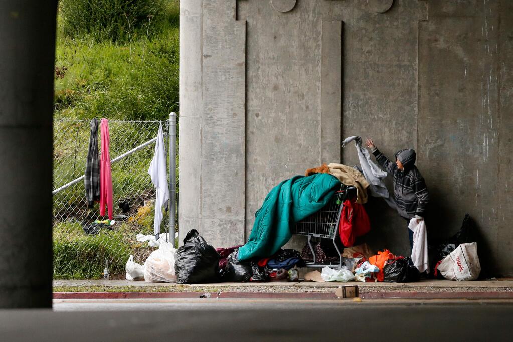 Xandria Thompson-Jones, who has been homeless for over five years, sorts through her belongings beneath the 5th Street Highway 101 overpass in Santa Rosa, California on Wednesday, January 4, 2017. (Alvin Jornada / The Press Democrat)