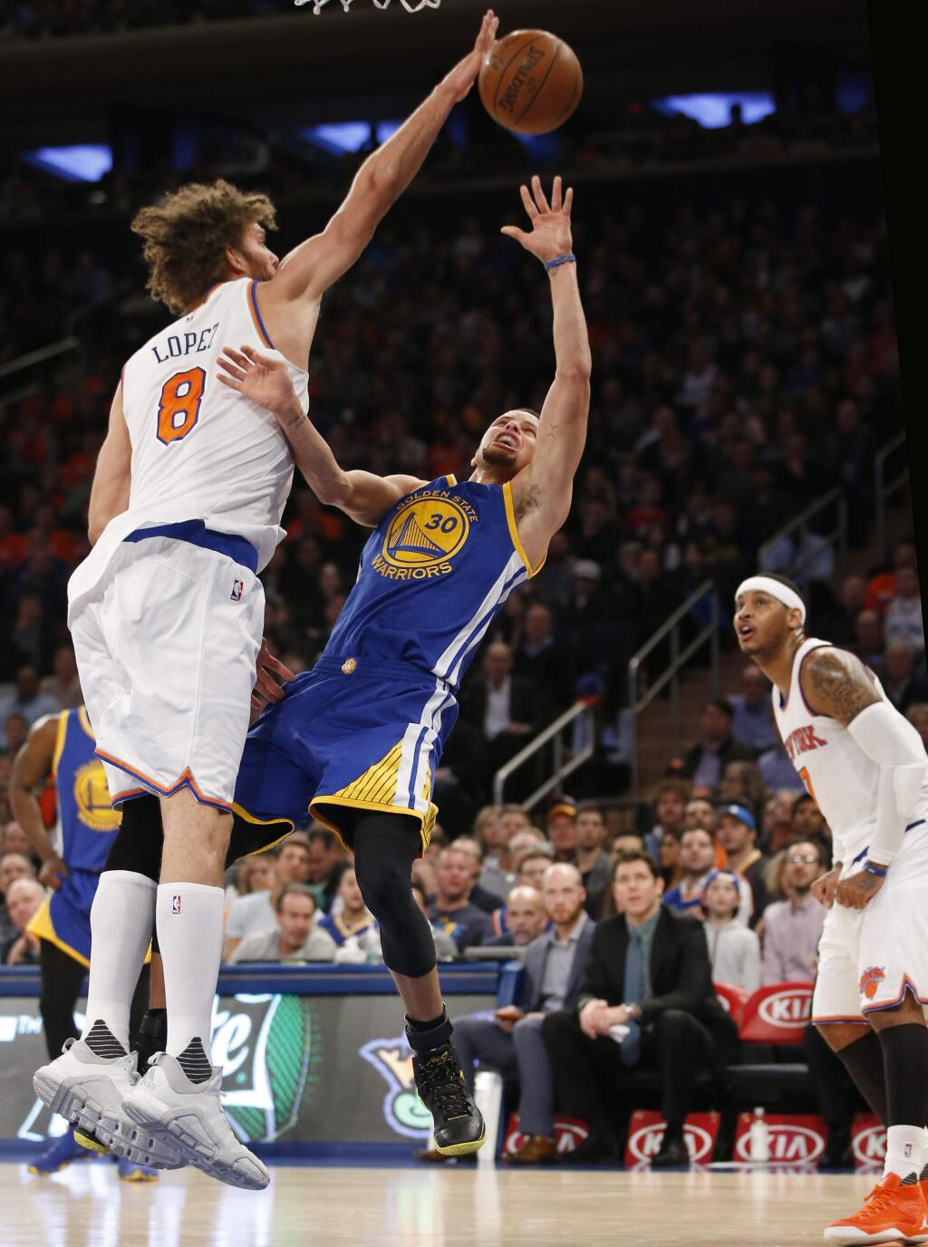 New York Knicks center Robin Lopez (8) blocks a shot by Golden State Warriors guard Stephen Curry (30) in the first half of an NBA basketball game at Madison Square Garden in New York, Sunday, Jan. 31, 2016. (AP Photo/Kathy Willens)