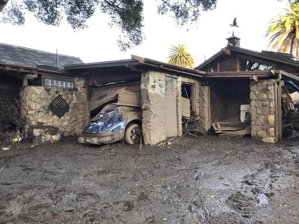 This photo provided by the Santa Barbara County Fire Department shows damage from mud, boulders, and debris that destroyed homes that lined Montecito Creek near East Valley Road in Montecito, Calif., Wednesday, Jan. 10, 2018. Anxious family members awaited word on loved ones Wednesday as rescue crews searched grimy debris and ruins for more than a dozen people missing after mudslides in Southern California destroyed over a 100 houses, swept cars to the beach and left more than a dozen victims dead. (Mike Eliason/Santa Barbara County Fire Department via AP)