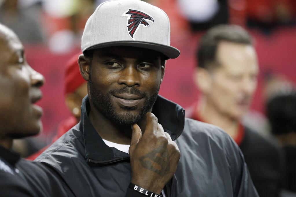 FILE - In this Jan. 1, 2017, file photo, former Atlanta Falcons quarterback Michael Vick stands on the sidelines before NFL football game between the Falcons and the New Orleans Saints in Atlanta. Vick told Fox Sports 1 Monday, July 17, 2017, that former San Francisco 49ers quarterback Colin Kaepernick should get a haircut in order to 'try to be more presentable' as he searches for another NFL job. (AP Photo/John Bazemore, File)
