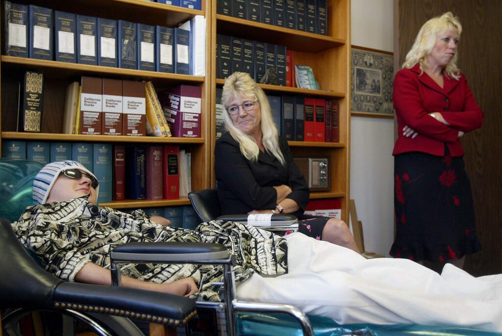 PC: Brandon Maxfield, 17, left, is shown with his grandmother Kandace Holder, center, and his mother Sue Stansberry in his lawyer Richard Ruggieri's office in San Rafael, Calif., Thursday, Aug. 12, 2004. Maxfield, of Willits, Calif., was paralyzed 10 years ago when his babysitter accidentally shot him. Maxfield failed Thursday in his attempt to purchase Bryco Arms, one of the nation's leading makers of inexpensive guns, in bankruptcy court. (AP Photo/Jeff Chiu)8/13/2004: B1: Brandon Maxfield, 17, his grandmother Kandace Holder, center, and his mother, Sue Stansberry, visit the office of his attorney, Richard Ruggieri, in San Rafael on Thursday.