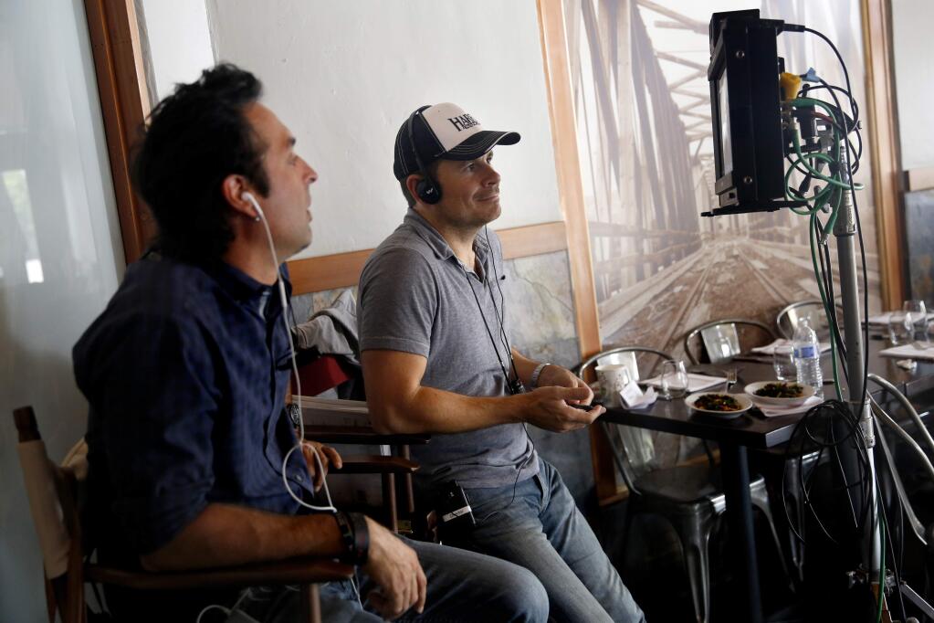 Joe Schwartz, left, and director Alex Ranarivelo watch on a monitor as actress Sharon Stone does a take during filming of the movie 'Running Wild' at the The Pullman Kitchen in Santa Rosa, on Monday, Aug. 17, 2015. (BETH SCHLANKER/ The Press Democrat)