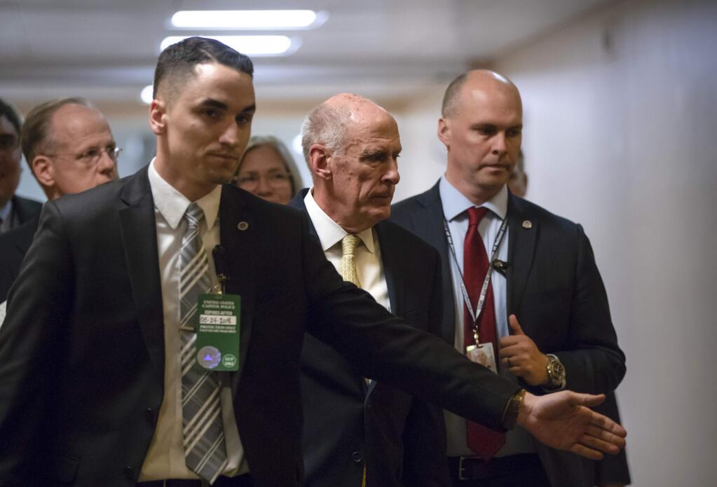 National Intelligence Director Dan Coats, center, is surrounded by security as he departs the Capitol after House and Senate lawmakers from both parties met for a classified briefing about the federal investigation into President Donald Trump's 2016 campaign, on Capitol Hill in Washington, Thursday, May 24, 2018. (AP Photo/J. Scott Applewhite)
