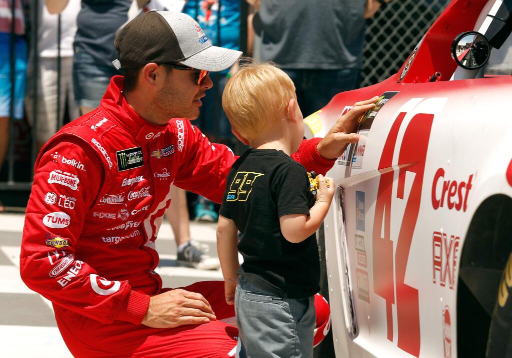Kyle Larson, driver of the No. 42 Target Chevrolet places the pole position winner sticker on his car with help from his son Owen during qualifying for the Monster Energy NASCAR Cup Series Toyota/Save Mart 350 at Sonoma Raceway, in Sonoma, California on Saturday, June 24, 2017. Larson is currently in first place in standings for the Monster Energy NASCAR Cup series. (Alvin Jornada / The Press Democrat)