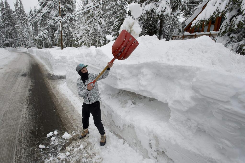 Ivan Andronik, of Rancho Cordova, Calif., shovels snow from in front of the house he and friends are renting Near Donner Lake on Saturday, Jan. 14, 2017. Recent snow has buried much of the area around Truckee and Donner Lake. ( Randall Benton /The Sacramento Bee via AP)