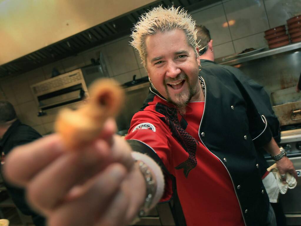 Santa Rosa's Guy Fieri displays a taquito that he and his crew prepared during a fundraiser at Chrome Lotus in Santa Rosa in 2010. (KENT PORTER/ PD FILE)