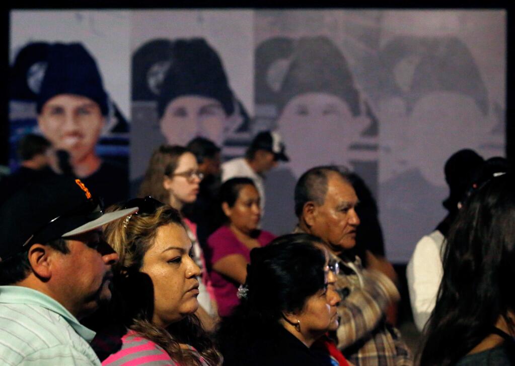 Supporters stand in front of a mural of Andy Lopez during a vigil on the second anniversary of the teen's shooting death in Santa Rosa on Thursday, October 22, 2015. (Alvin Jornada / The Press Democrat)