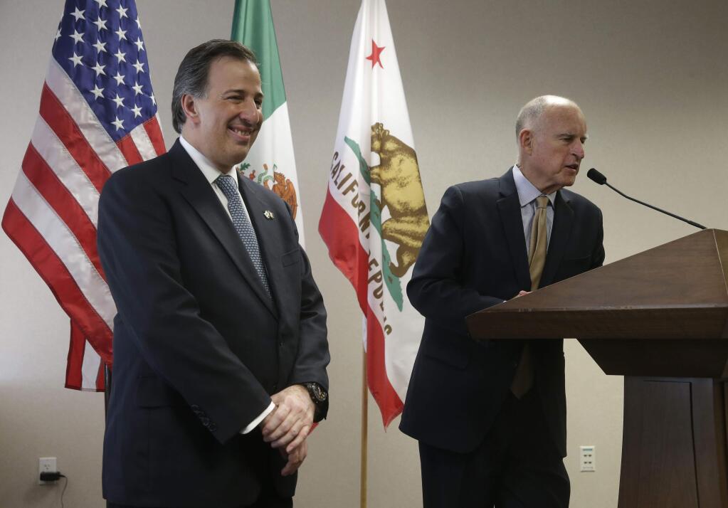 Mexican Secretary of Foreign Affairs Jose Antonio Meade Kuribrena, left, smiles at Gov. Jerry Brown's response to a reporter's question during a news conference, Wednesday, July 23, 2014, in Sacramento. (AP Photo/Rich Pedroncelli)