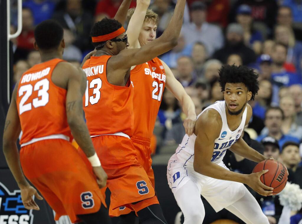 Duke's Marvin Bagley III, right, looks to pass around Syracuse's Frank Howard (23), Paschal Chukwu (13) and Marek Dolezaj (21) during the second half of a region semifinal game in the NCAA tournament Friday, March 23, 2018, in Omaha, Neb. (AP Photo/Charlie Neibergall)