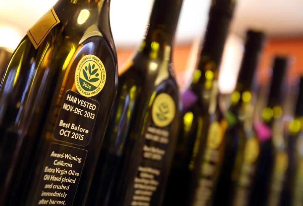 Bottles of olive oil at The Olive Press, in Sonoma, are marked with a certified extra virgin sticker from the California Olive Oil Council.(Christopher Chung/ The Press Democrat)