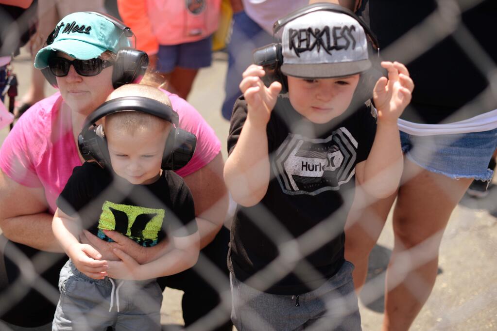 Nichole Kindred with her son Wyatt, 3, Carson, 6, and her wife Crystal Kindred, far right, from Fairfield at the fence watching racing during the Toyota NHRA Sonoma Nationals held Sunday at Sonoma Raceway. (Erik Castro/for The Press Democrat)