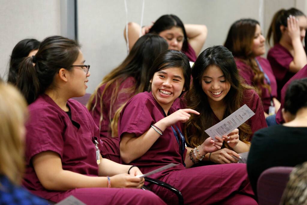 Windsor High School students Melanie Ngo, left, and Joanna Nguyen and Piner High School student Mary Nguyen, right, laugh together as they before their graduation from the Health Careers Academy at Kaiser Hospital in Santa Rosa, California on Thursday, April 28, 2016. Health Careers Academy is a pilot program that introduces Sonoma County high school students to healthcare careers by providing them with semester-long job shadows, laboratory and fieldwork experiences. (Alvin Jornada / The Press Democrat)