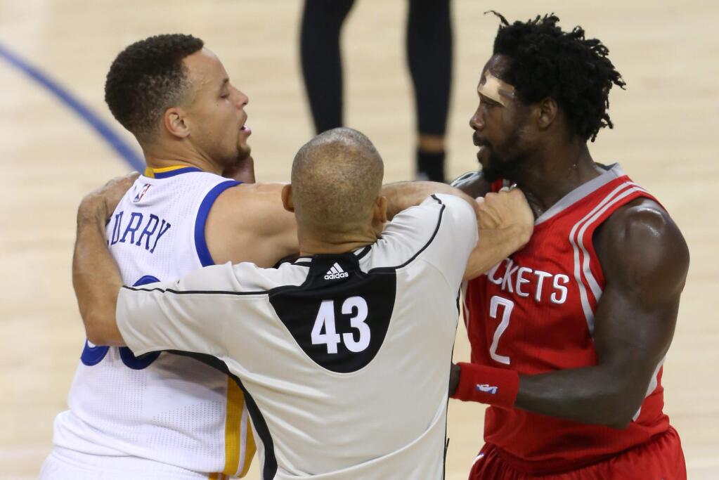 Referee Dan Crawford, center, separates Golden State Warriors guard Stephen Curry, left, and Houston Rockets guard Patrick Beverley, during their game in Oakland on Saturday, April 16, 2016. The Warriors defeated the Rockets 104-78.(Christopher Chung/ The Press Democrat)