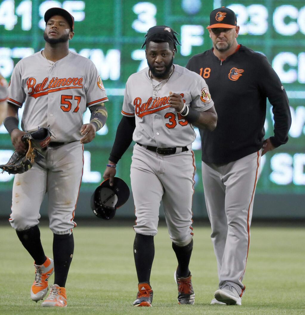 Baltimore Orioles' Hanser Alberto (57) and manager Brandon Hyde, right, walk in from the outfield with left fielder Dwight Smith Jr. after Smith hit the wall hard while catching a fly ball by Texas Rangers' Rougned Odor during the fourth inning of a baseball game in Arlington, Texas, Thursday, June 6, 2019. (AP Photo/Tony Gutierrez)