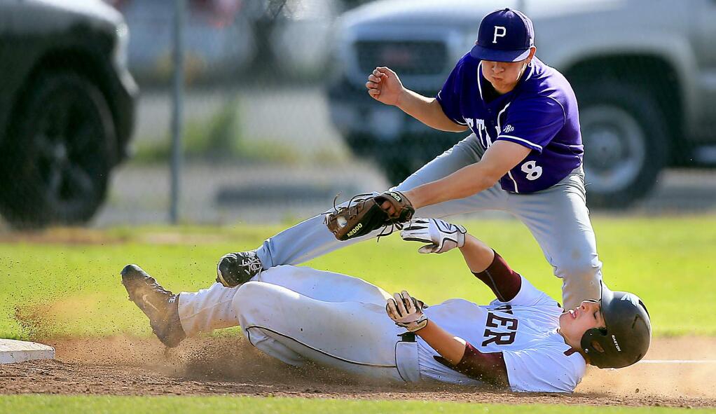 Piner's Rickery Christensen slides in to third as Petaluma's Connor Richardson applies the tag during a three run sixth inning at Piner High School in Santa Rosa, Tuesday April 26, 2016. Christensen was called safe on the play after Richardson dropped the ball. (Kent Porter / Press Democrat ) 2016