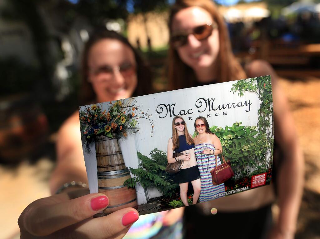 Kellie Power, left and Katy Quigg of San Francisco show off a souvenir during the Taste of Sonoma at the MacMurray Ranch in Healdsburg, Saturday Aug. 31, 2013. (Kent Porter / Press Democrat) 2013