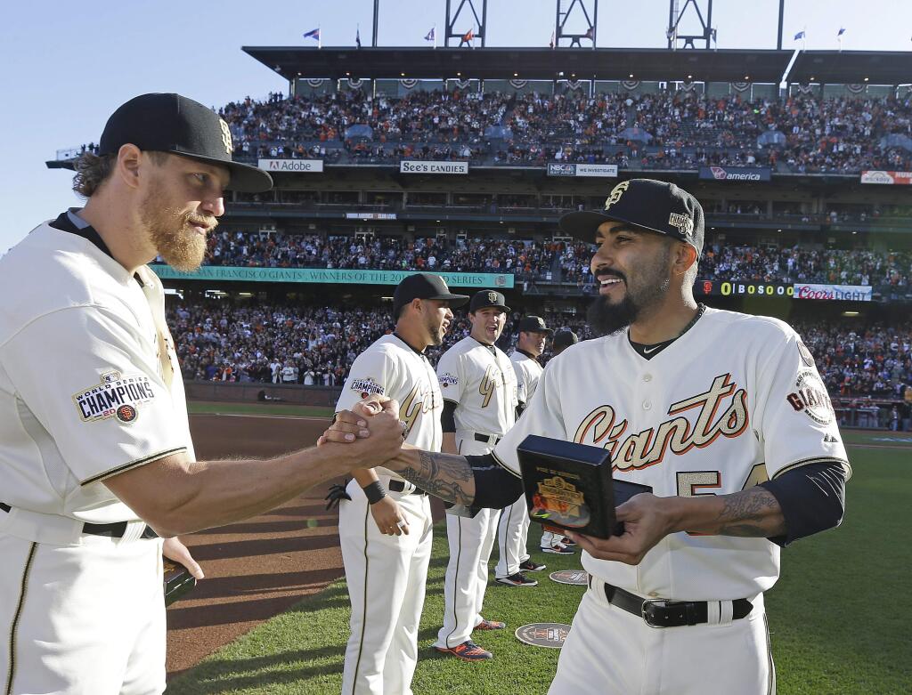 San Francisco Giants' Hunter Pence, left, shakes hands with Sergio Romo during the 2014 World Series championship ring ceremony before the Giants' game against the Arizona Diamondbacks on Saturday, April 18, 2015, in San Francisco. (AP Photo/Ben Margot, Pool)
