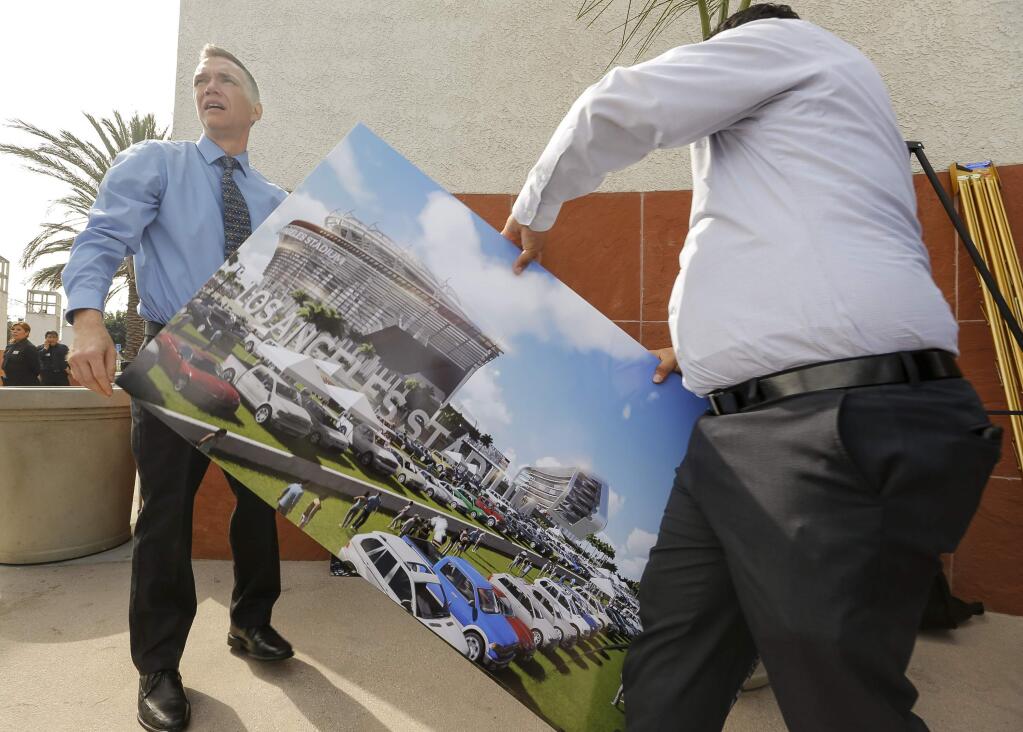 A rendering for a proposed NFL football stadium by the owners of the San Diego Chargers and Oakland Raiders, is packed after a news conference in Carson, Calif., on Friday, Feb. 20, 2015. (AP Photo/Damian Dovarganes)