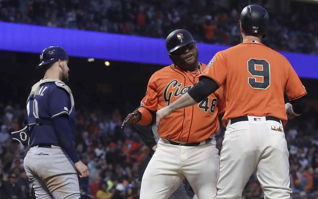 San Francisco Giants' Pablo Sandoval, center, celebrates after hitting a two-run home run that scored Brandon Belt (9) against the Milwaukee Brewers during the fourth inning of a baseball game in San Francisco, Friday, June 14, 2019. At left is Brewers catcher Yasmani Grandal. (AP Photo/Jeff Chiu)