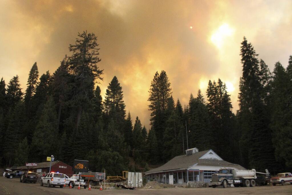 In this Tuesday, Aug. 29, 2017 photo, smoke rises from a wildfire behind the Fish Camp General Store near Yosemite National Park in Fish Camp, Calif. The wildfire is among a series of wildfires burning across the U.S. West. (Brian Wilkinson, Sierra Star via AP)
