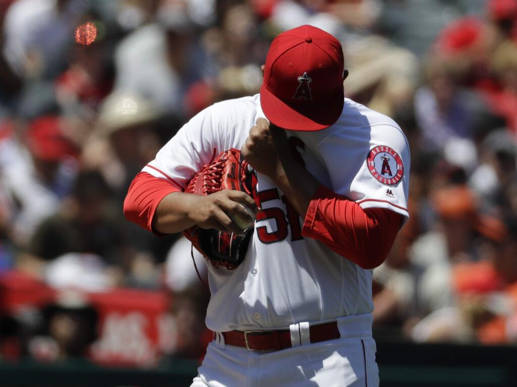 Los Angeles Angels starting pitcher Jaime Barria wipes his face during the first inning of a baseball game against the San Francisco Giants in Anaheim, Calif., Sunday, April 22, 2018. (AP Photo/Chris Carlson)