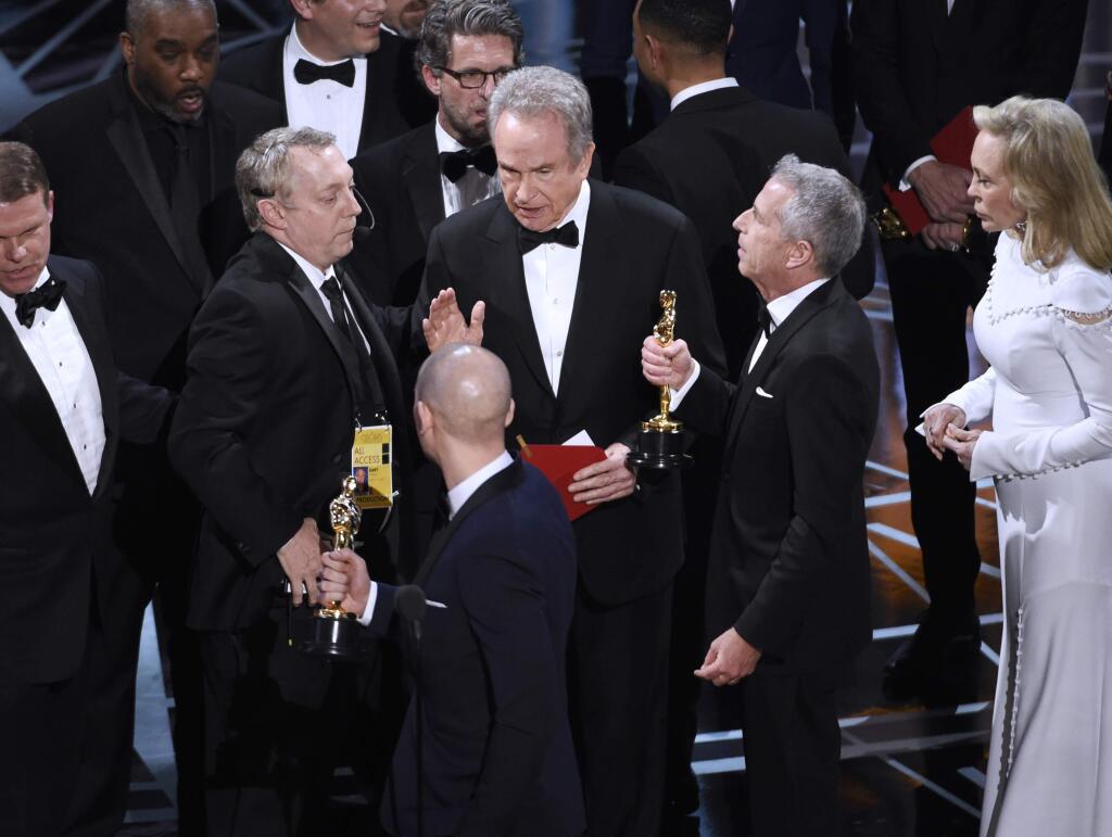 Warren Beatty, center, discusses the results of the award for best picture with Academy of Motion Pictures Arts and Sciences officials and producers from 'La La Land' at the Oscars on Sunday, Feb. 26, 2017, at the Dolby Theatre in Los Angeles. (Photo by Chris Pizzello/Invision/AP)