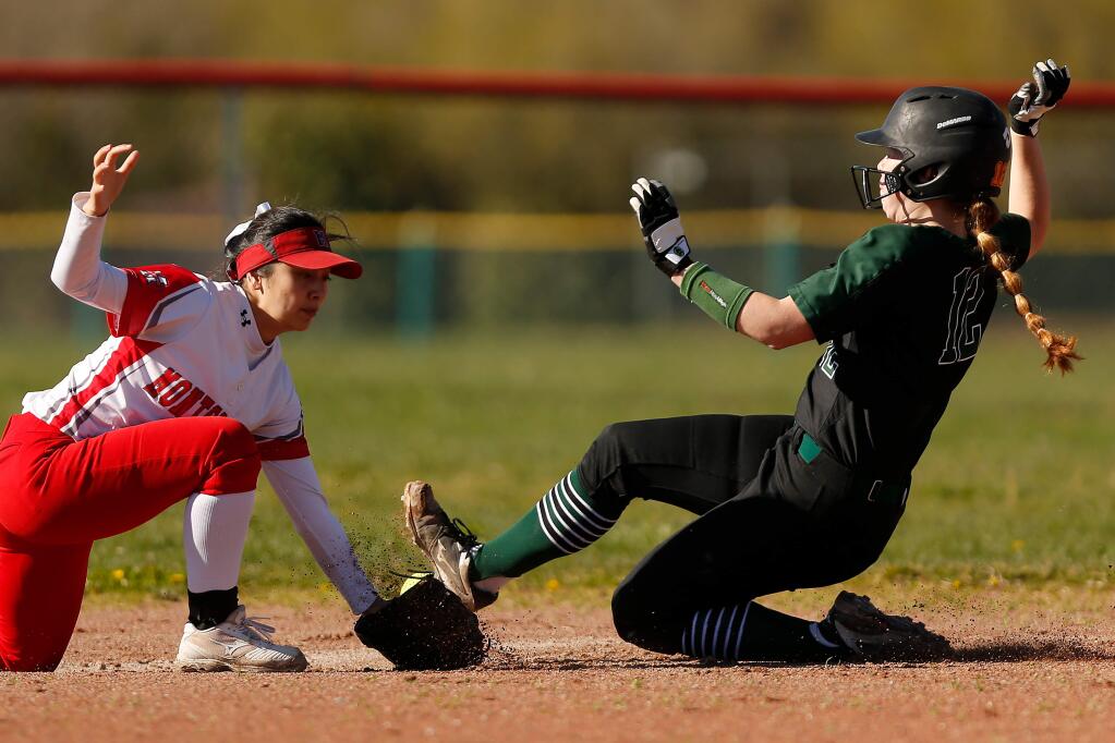 Sonoma Valley's Abby Alcayaga (12), right, slides and knocks the ball out of the glove of Montgomery's Olivia Gabriel (9) allowing Alcayaga to reach second base safely, during a girls varsity softball game in Santa Rosa on Tuesday, March 12, 2019. (Alvin Jornada / The Press Democrat)