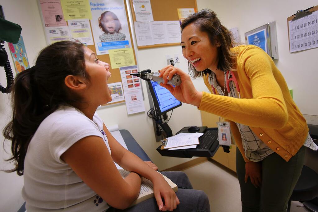 Pediatric nurse practitioner Julia Chang examines Gabriella Cedillos, 11, during her annual physical, at Roseland Pediatrics, part of Santa Rosa Community Health Centers, in Santa Rosa, on Wednesday, November 30, 2016. (Christopher Chung/ The Press Democrat)