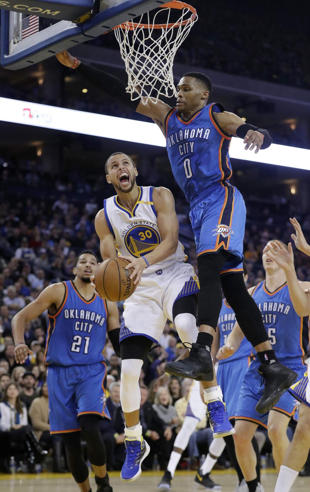 Golden State Warriors' Stephen Curry (30) is fouled while driving to the basket by Oklahoma City Thunder's Russell Westbrook (0) during the second half of an NBA basketball game Wednesday, Jan. 18, 2017, in Oakland, Calif. (AP Photo/Marcio Jose Sanchez)