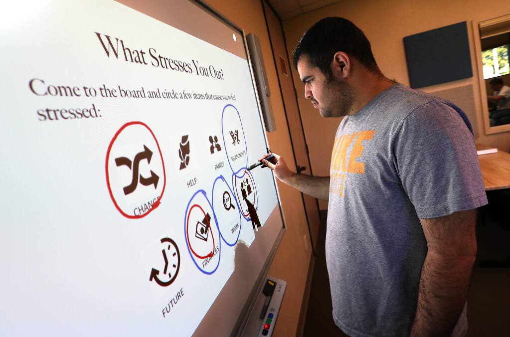 Client Isa House, 19, circles some of the things that cause him stress on a 'smart board' in the Becoming Independent Passport to Independence program for people with autism. (JOHN BURGESS / The Press Democrat)