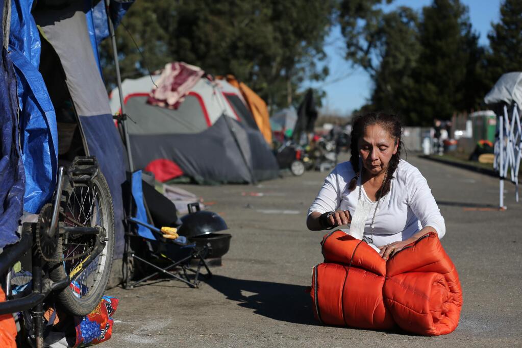 Stephanie 'Cricket' Somersall packs up her sleeping bag before Sonoma County sheriff's deputies arrived at a homeless encampment along an unused portion of Bane Avenue just south of West Robles Avenue in Santa Rosa on Monday, Feb. 10, 2020. (Beth Schlanker / The Press Democrat)
