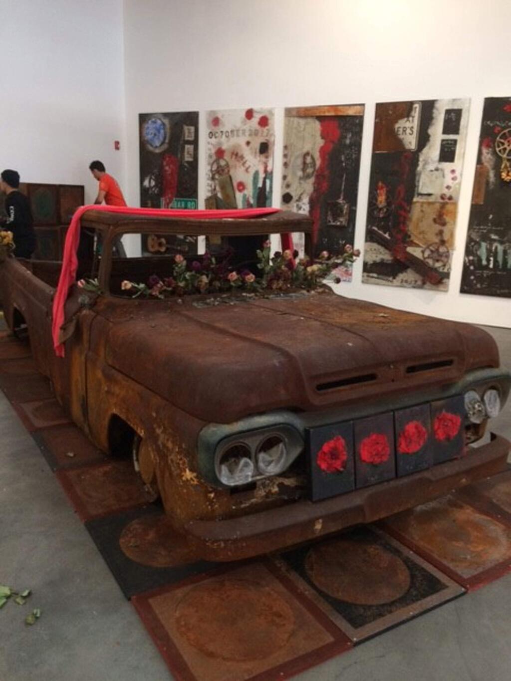 A mixed-media installation of a burned truck adorned with flowers by Adam Shaw is called “Beauty Born in Flames.” (Museums of Sonoma County)