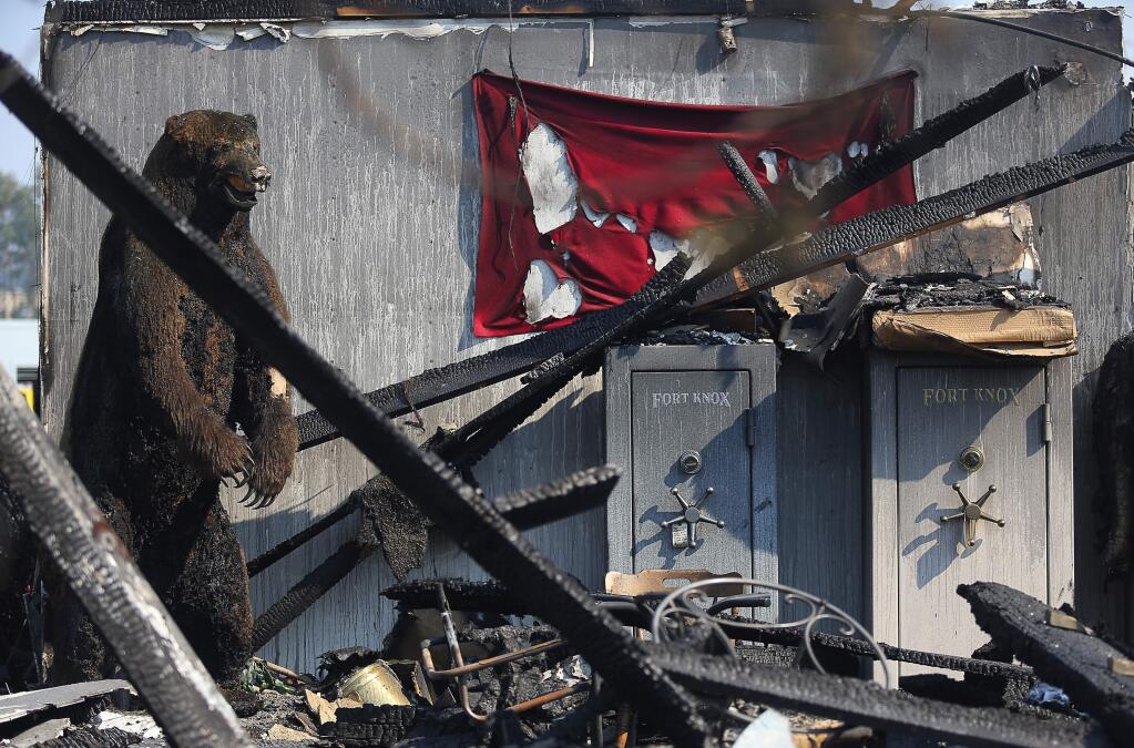 A large taxidermied bear remains standing at the site of the fire ravaged Schmidt Firearms store in Santa Rosa on Wednesday, October 18, 2017. (Christopher Chung/ The Press Democrat)