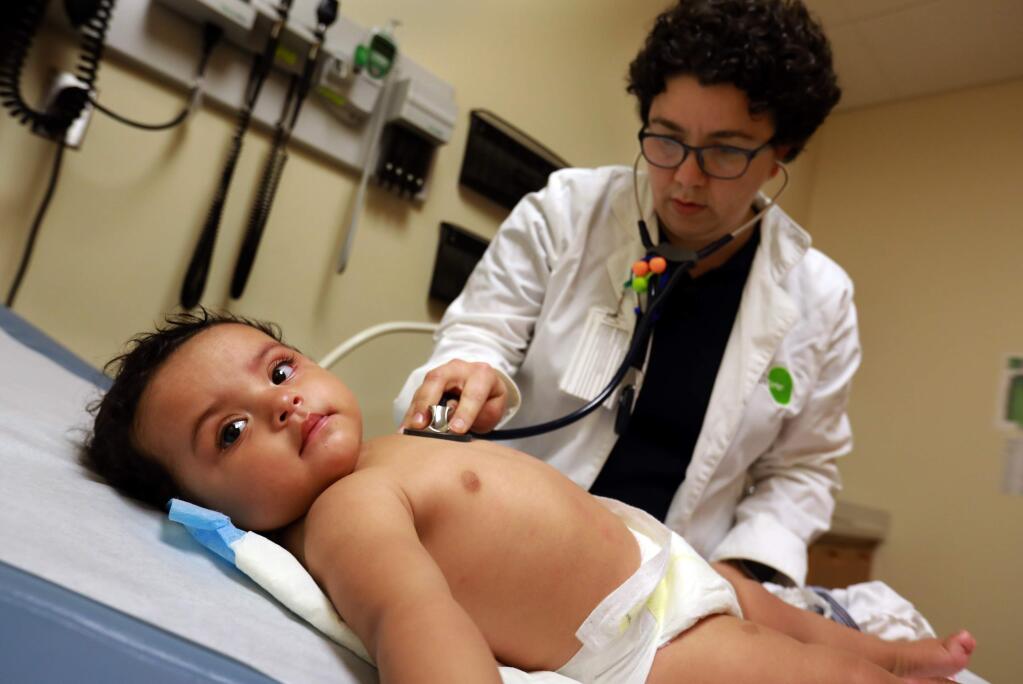 Dr. Danielle Oryn checks the heartbeat of Kassandra Rodriquez, 8 months, at the Petaluma Health Center on Thursday, June 16, 2017. (John Burgess/The Press Democrat)