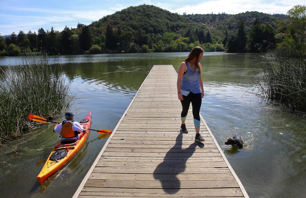 Gene Fanucchi, left, heads out into Spring Lake on his kayak, while Brittany Dybdahl helps guide Layla back to shore, in Santa Rosa, on Friday, September 2, 2016. (Christopher Chung/ The Press Democrat)