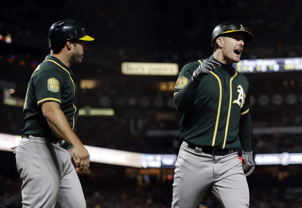 The Oakland Athletics' Mark Canha, right, celebrates his two-run home run with Josh Phegley, left, during the seventh inning against the San Francisco Giants on Saturday, July 14, 2018, in San Francisco. (AP Photo/Marcio Jose Sanchez)