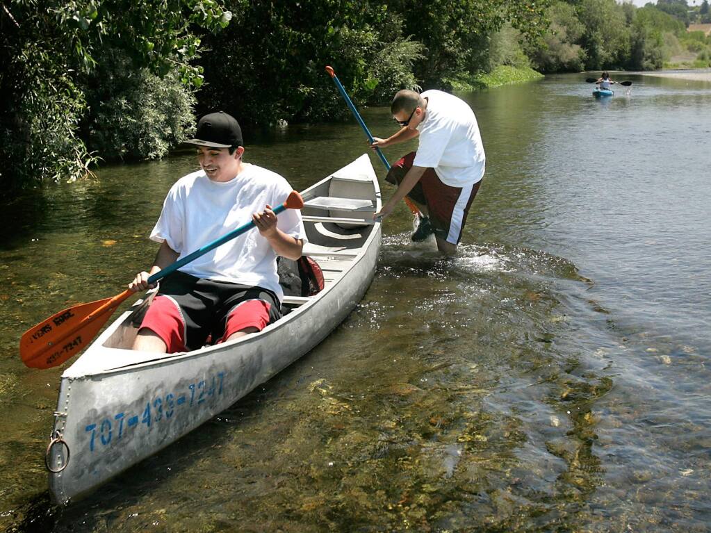 (File photo) David Narvaez of San Francisco pushes his friend Hugo Gomez through the shallow waters of the Russian River east of Healdsburg (2009)