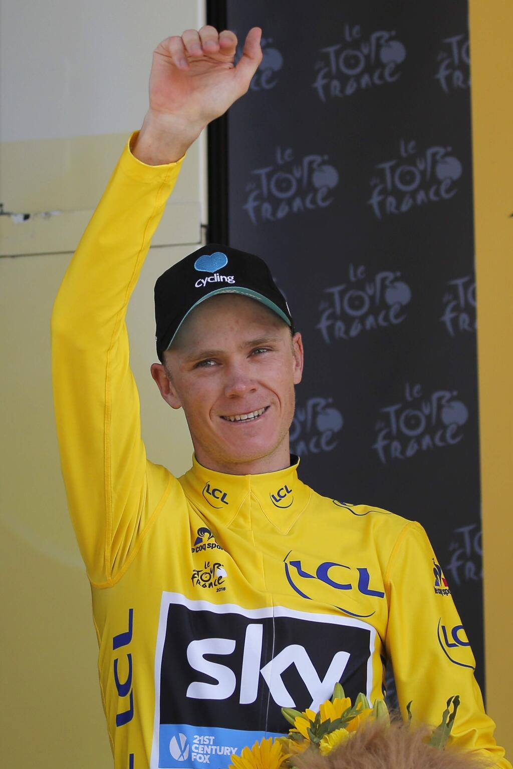 Britain's Chris Froome, wearing the overall leader's yellow jersey, celebrates on the podium after the seventeenth stage of the Tour de France cycling race over 184.5 kilometers (114.3 miles) with start in Bern and finish in Finhaut-Emosson, Switzerland, Wednesday, July 20, 2016. (AP Photo/Christophe Ena)
