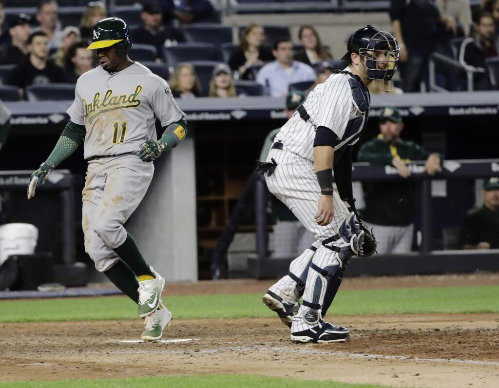Oakland Athletics' Rajai Davis (11) passes New York Yankees catcher Austin Romine to score on a single by Jed Lowrie during the eighth inning of a baseball game Friday, May 26, 2017, in New York. (AP Photo/Frank Franklin II)
