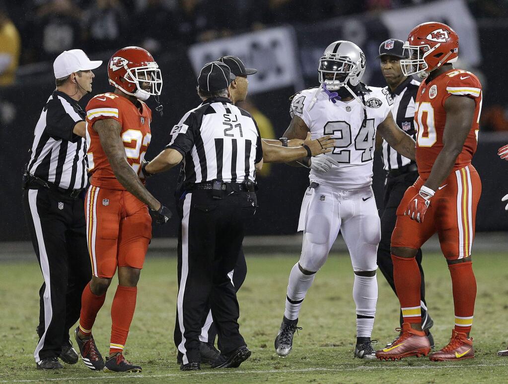 Oakland Raiders running back Marshawn Lynch (24) talks with officials before he was ejected during the first half Thursday, Oct. 19, 2017. (AP Photo/Ben Margot)