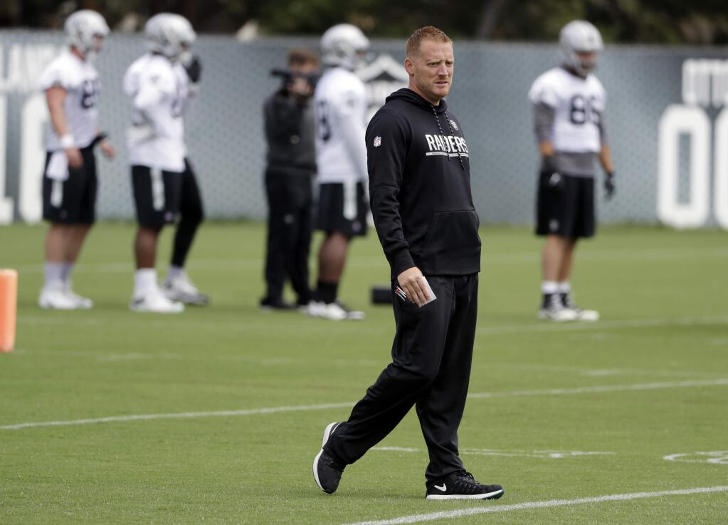 In this May 30, 2017, file photo, Oakland Raiders offensive coordinator Todd Downing watches drills during the team's organized team activity at its training facility in Alameda. Downing has spent the past two years building up a relationship with Derek Carr as his quarterbacks coach. The two play golf, talk current events and most importantly immerse themselves in all aspects of football. With Downing heading into his first game as NFL play-caller following an offseason promotion to coordinator, the hope is the strength of that relationship will pay big dividends on the field. (AP Photo/Marcio Jose Sanchez, File)
