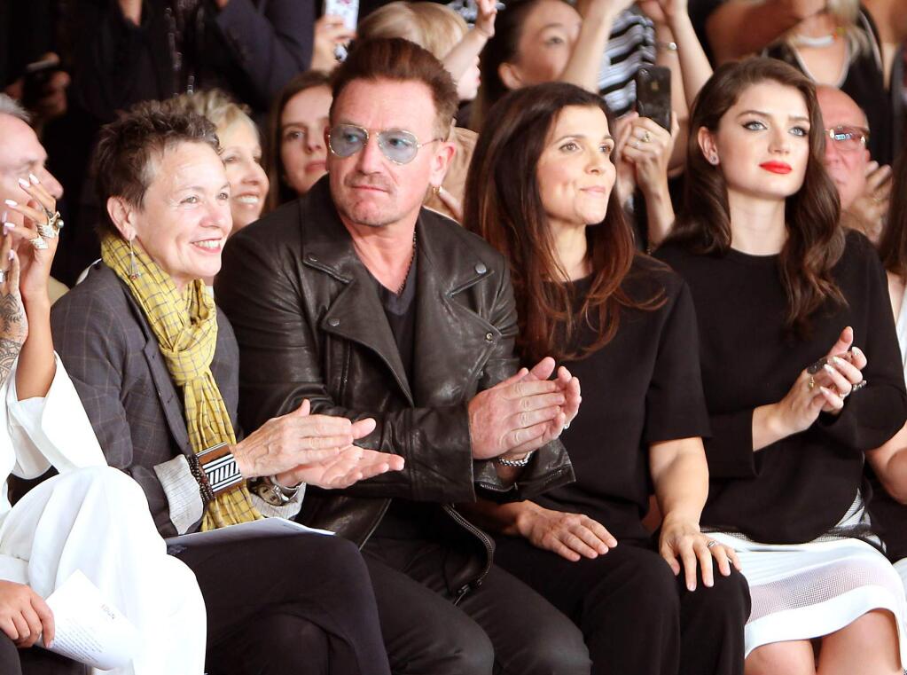 FILE- In this Sept. 7, 2014 file photo released by Starpix, Laurie Anderson, from left, Bono, Ali Hewson, and Eve Hewson sit in the front row during the Edun Spring 2015 collection during Fashion Week in New York. Bono says his ever-present sunglasses aren't a rock-star affectation ó he has suffered from glaucoma for 20 years. told the BBC's 'Graham Norton Show' that he had the condition, but 'I have good treatments and I am going to be fine. (AP Photo/Starpix, Kristina Bumphrey, File)