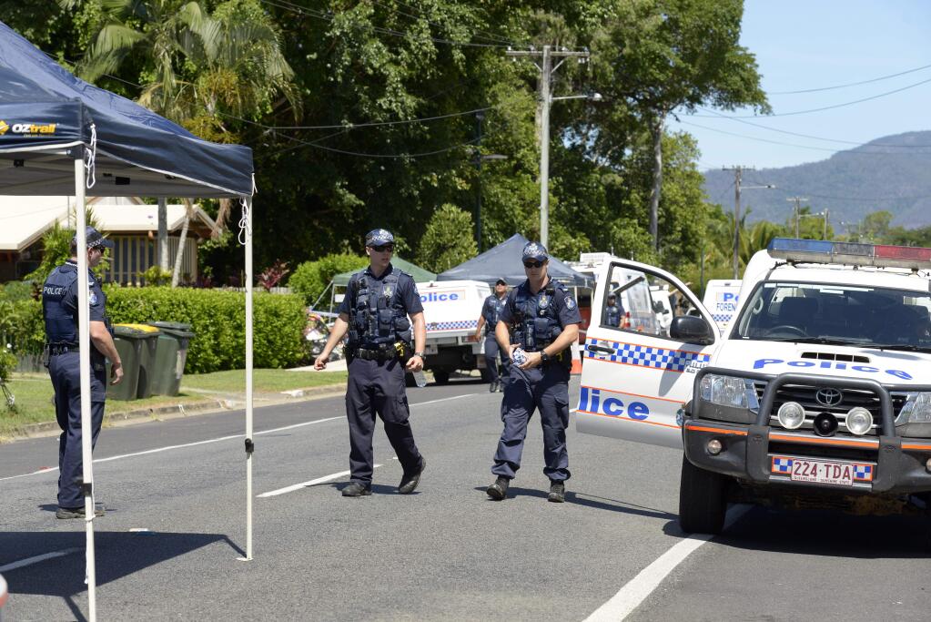 Police patrol near a house where eight children have been found dead in a Cairns suburb in far north Queensland, Australia, Friday Dec 19, 2014. Queensland state police said they were called to the home in the Cairns suburb of Manoora on Friday morning after receiving a report of a woman with serious injuries. When police got to the house, they found the bodies of the children inside, ranging in age from 18 months to 15 years.(AP Photo/Graeme Bint)