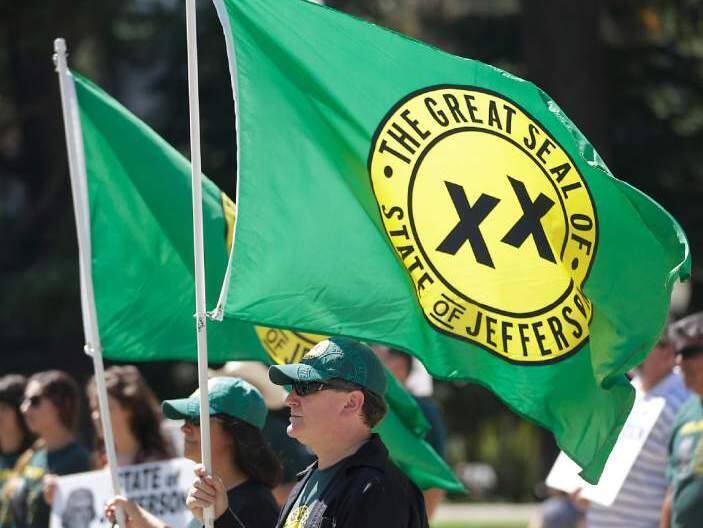 With flags showing the double XX, representing the state of Jefferson, fluttering in the breeze, dozens of residents from several rural counties rallied at the Capitol calling for the creation of the 51st state Thursday, Aug. 28, 2014, in Sacramento, Calif. (AP Photo/Rich Pedroncelli)