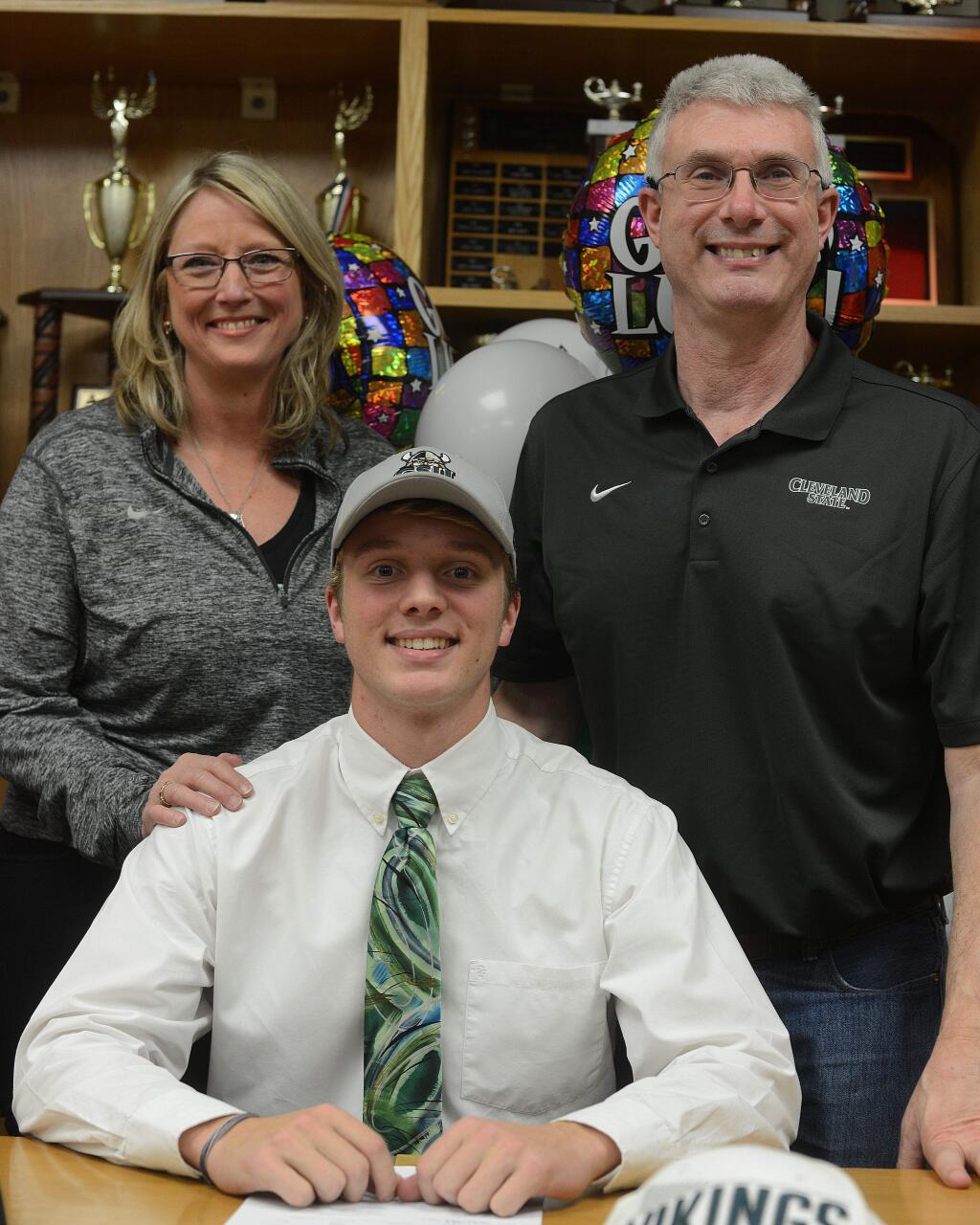 SUMNER FOWLER/FOR THE ARGUS-COURIERIan McKissick, with mother, Lisa, and father, Ronald, looking on, signs to play lacrosse at Cleveland State University.