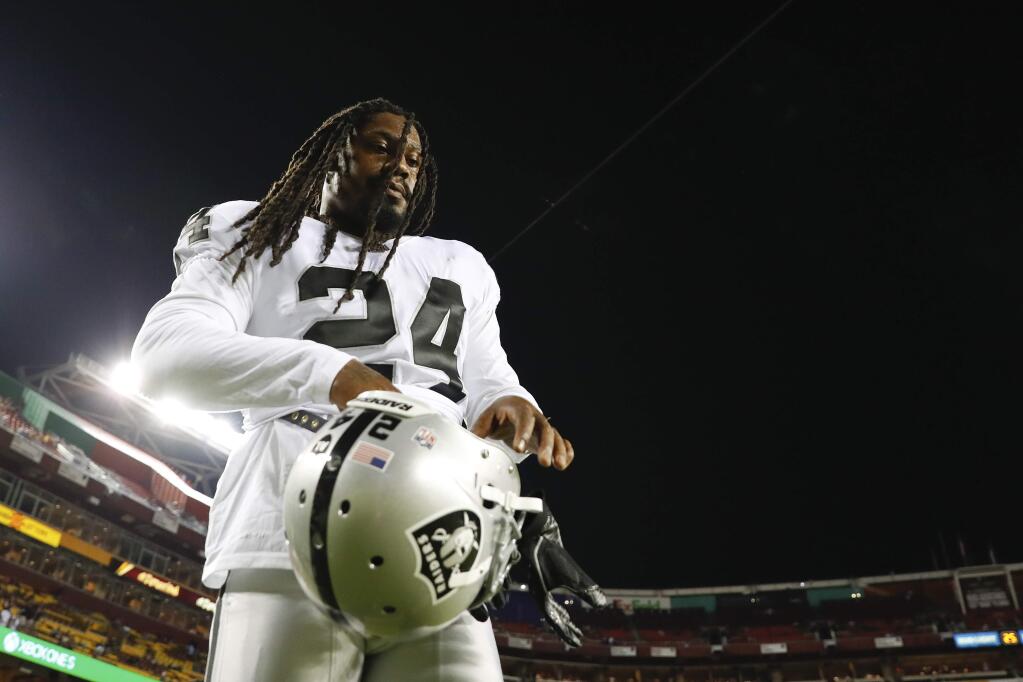 In this Sept. 24, 2017, file photo, Oakland Raiders running back Marshawn Lynch (24) puts on his helmet before a game against the Washington Redskins in Landover, Md. The Raiders play at Miami on Sunday night, and both teams are reeling. The Raiders have lost five of their past six games, including a 34-14 thumping last Sunday at Buffalo. The Dolphins are coming off a 40-0 loss at Baltimore, their worst defeat in 20 years. (AP Photo/Alex Brandon, File)