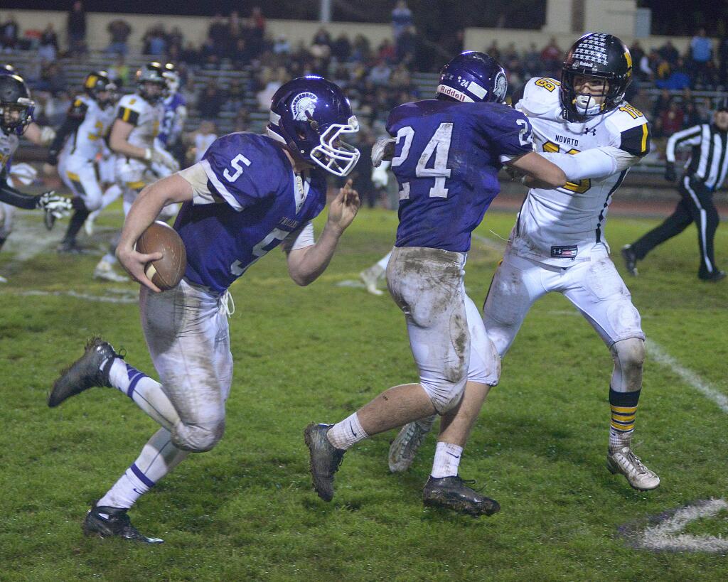SUMNER FOWLER/FOR THE ARGUS-COURIERPetaluma quarterback Brendan White gets a block from Conor Richardson to spring for a big gain in the Trojans' 38-20, NCS win over Novato.