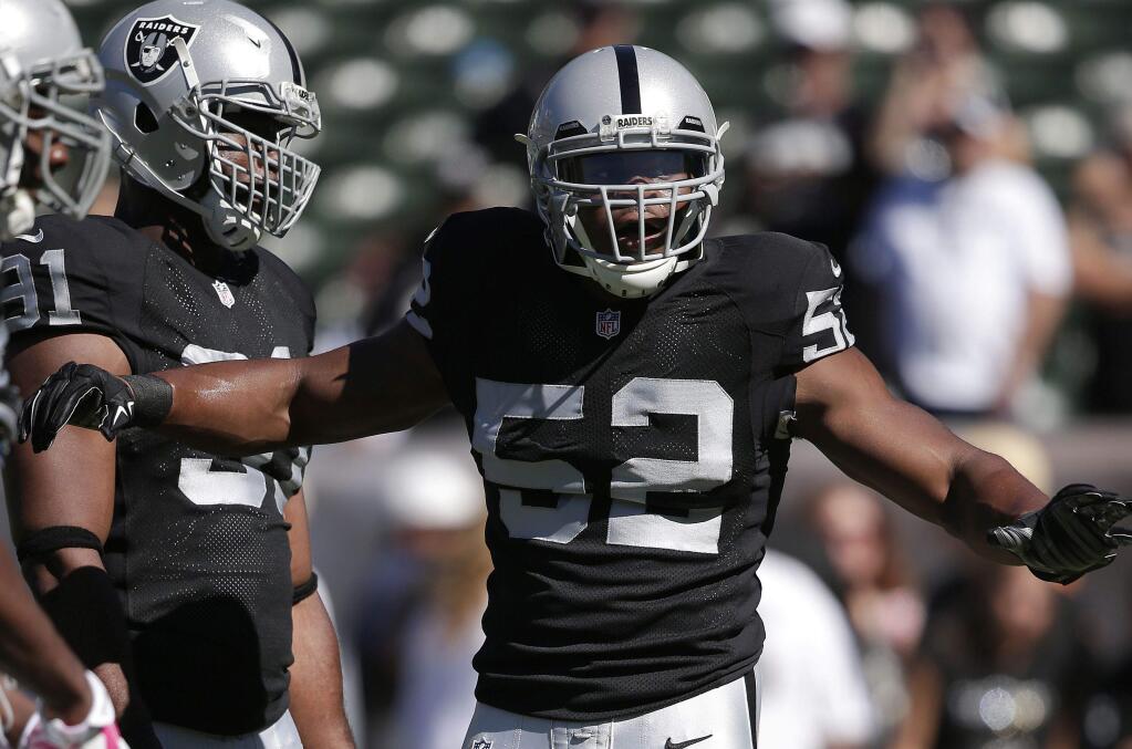 Raiders rookie outside linebacker Khalil Mack (52) works out with teammates before the Oct. 12 game in Oakland against the San Diego Chargers. (Associated Press / Marcio Jose Sanchez)